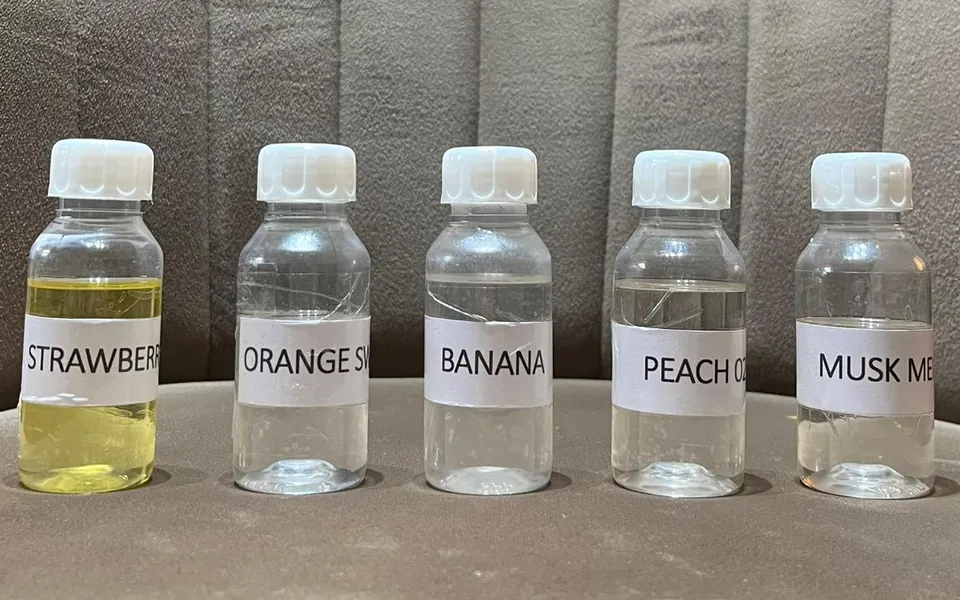 Five flavour sample bottles labelled strawberry, orange, banana, peach and musk melon